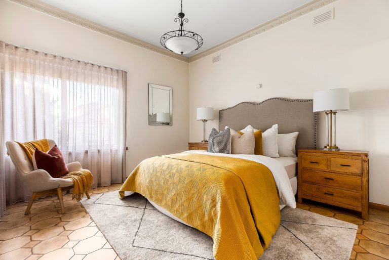 Vintage bedroom styling with mustard accents, soft neutral palette, and natural light to create a warm inviting feel