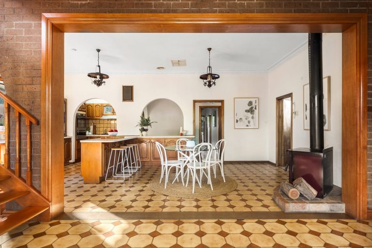 Spacious vintage home interior with timber staircase, open dining zone, and light styling to enhance natural warmth